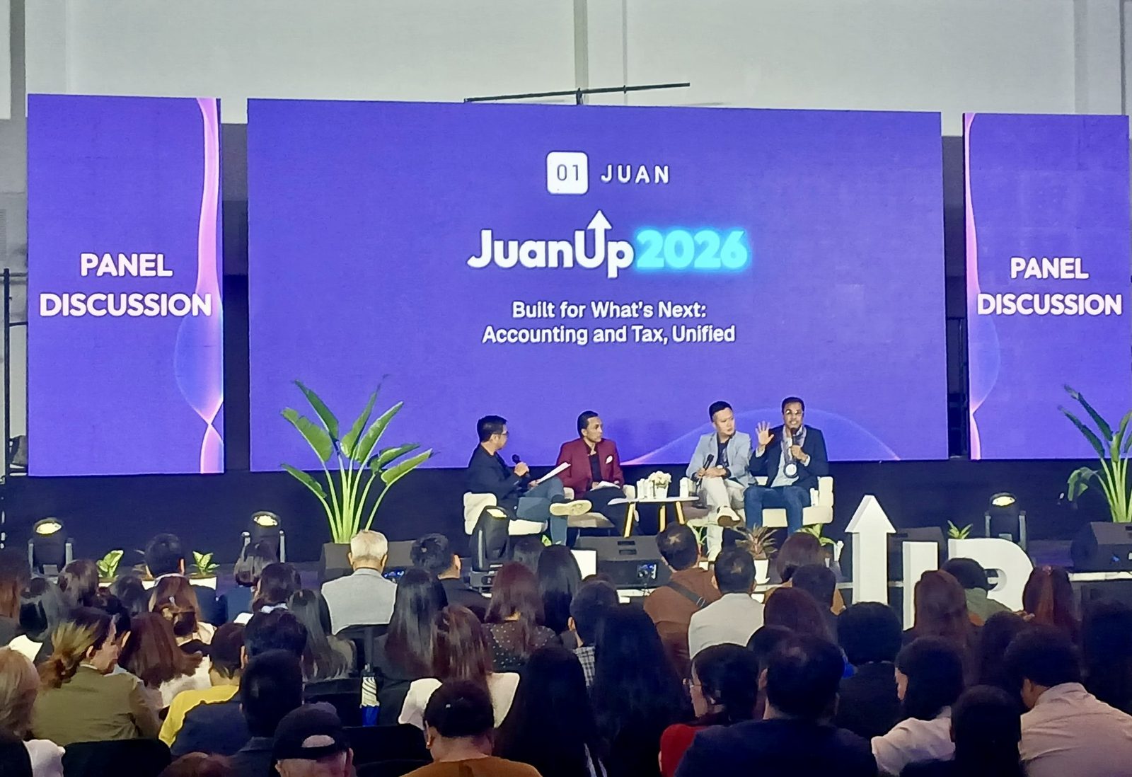 The JuanUp 2026 panel discussion on stage at Whitespace Manila, with Jerry Ilao speaking to a full audience