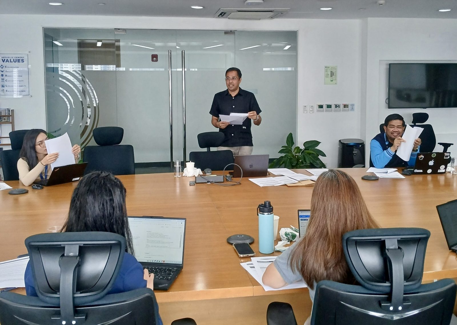 Jerry Ilao facilitating Republic Cement's AI Champions workshop — participants working through their Microsoft Copilot agent materials in the boardroom