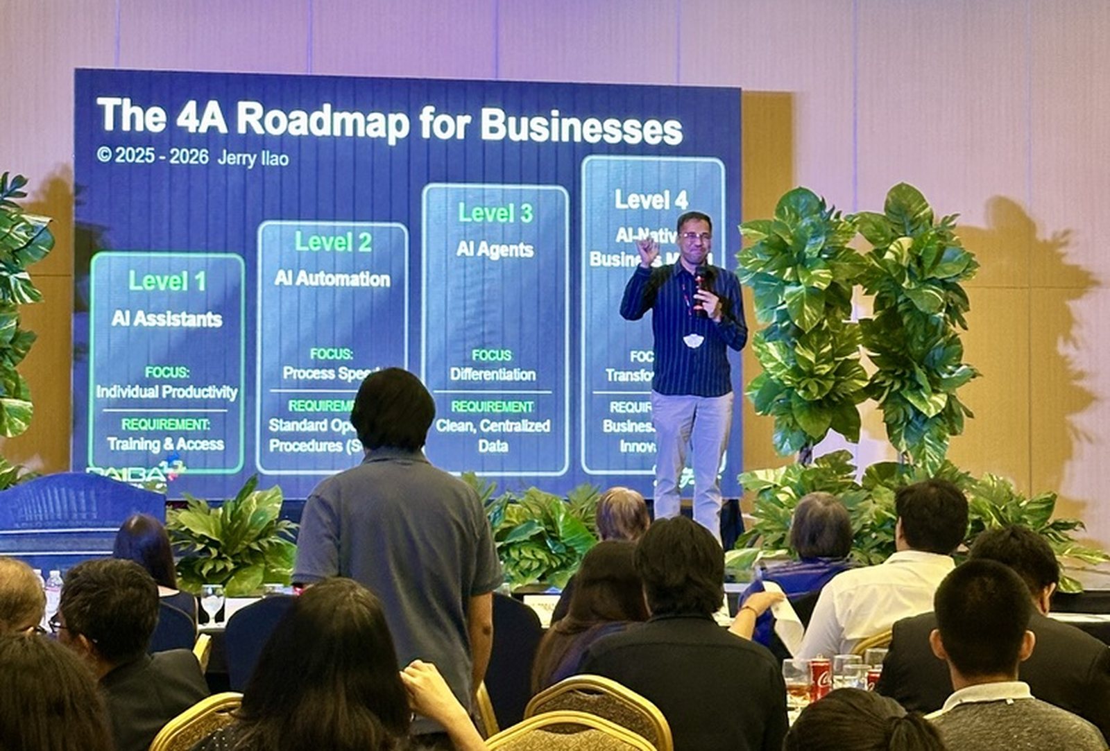 Jerry Ilao on stage teaching The 4A AI Roadmap to a room of Filipino business owners, with the four-level slide behind him